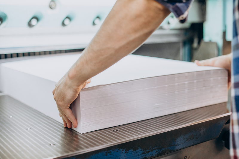 Stack of cut sheets being loaded onto a guillotine cutter